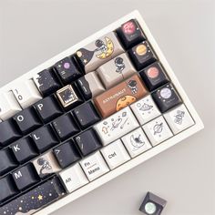 a computer keyboard sitting on top of a white table next to a mouse and pen