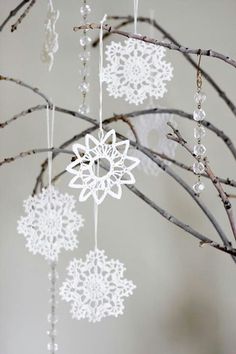 an ornament hanging from a tree branch with snowflakes attached to it