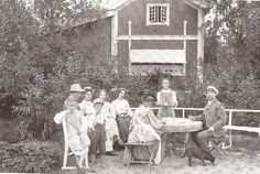 an old black and white photo of people in front of a house with a dog