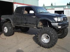 a large black truck parked in front of a building