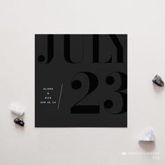 a black and white poster with the words july 23 on it next to some rocks