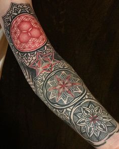 a man's arm with tattoos on it and an intricate design in the middle