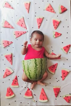 a baby is sitting in front of watermelon slices