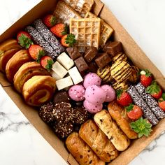 a box filled with lots of different types of pastries and desserts next to each other