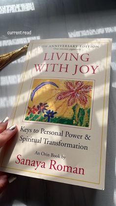 a person holding a book in their hand with the title living with joy keys to personal power and spiritual information