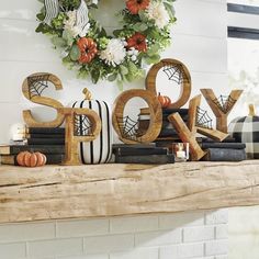 a fireplace mantel decorated for halloween with pumpkins, books and decorations on it