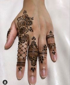 a woman's hand with henna tattoos on it