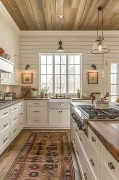 a kitchen with white cabinets and wood floors, along with a rug on the floor