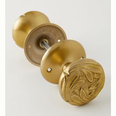 two brass door knobs with decorative designs on them