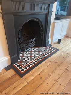 a fireplace with a black and white checkered rug on the floor next to it