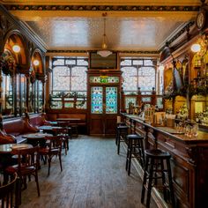 the interior of a bar with many tables and chairs