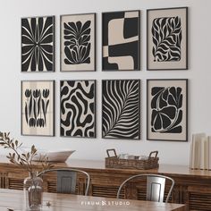 four black and white art pieces hanging on the wall above a dining room table with chairs