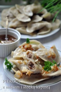 some dumplings are sitting on a plate with dipping sauce