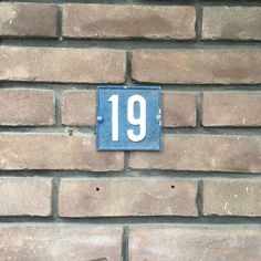 a brick wall with a blue plaque that reads 19 on it and the number nineteen