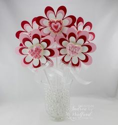 a vase filled with paper flowers on top of a white table