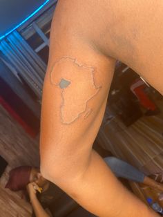 a person with a small tattoo on their arm and leg in the shape of africa