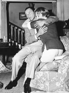 an old photo of a man and child hugging each other on the couch in their living room