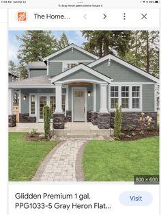 a gray house with white trim on the front door and windows is featured in this magazine