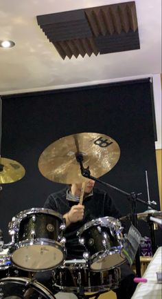 a man is playing drums in a recording studio