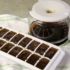 an ice tray filled with brownies next to a blender on a tablecloth