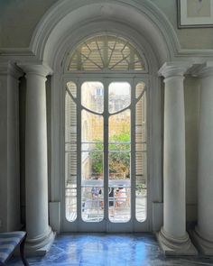 an arched doorway with columns and blue floor