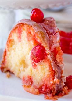 a close up view of a piece of cake with strawberries on it and icing