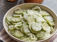 a bowl filled with sliced cucumbers on top of a table