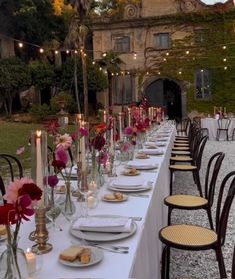 a long table is set with plates and candles