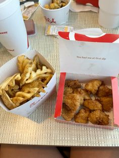 two takeout boxes filled with fried food on top of a table