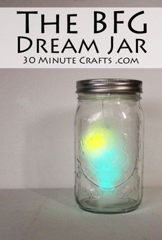 a mason jar filled with liquid sitting on top of a white table next to a sign that says the big dream jar 30 minute crafts