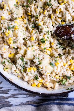 a pot filled with rice and corn on top of a table