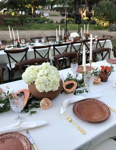 the table is set with plates, silverware and flowers