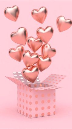 a pink box filled with hearts flying out of it's top and bottom side