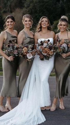 three bridesmaids are standing in the street with their bouquets