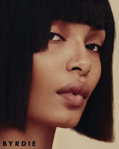 a close up of a woman with black hair and bangs on her head, looking to the side