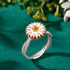 Daisy flowers represent innocence and they are usually linked to children or newborns, it is also a symbol of a new beginning. Beautifully handcrafted in sterling silver, this ring features a charming daisy and two rows of petite pave-set round brilliant-cut stones intertwine for a timeless style. The top part of the ring is rotatable, can be spun smoothly. Stunning and sparkling, this nature-inspired ring will capture your heart at first sight.Carat Weight: 0.15 ctStone Size: 3.5 mmStone Type: Jeulia® StoneNumber of Stones: 1 Stone Shape: RoundStone Color: Citrine YellowCarat Weight: 0.74 ctStone Size: 1 mmStone Type: Jeulia® StoneNumber of Stones: 74 Stone Shape: RoundStone Color: Diamond WhiteWeight: 5.6 gWidth: 3.9 mmHeight: 6.4 mmThickness: 1.5 mmMaterial: 925 SilverPlating Color: Sil White Flower-shaped Jewelry With Sunflower Design, White Flower Jewelry With Sunflower Design, Rose Gold Sterling Silver Flower Rings, White Sunflower Design Flower Jewelry, Fine Jewelry Sterling Silver Flower Ring With Birthstone, Fine Jewelry Flower Ring With Birthstone In Sterling Silver, White Gold Flower Ring With Birthstone, Hallmarked Flower Ring For Anniversary, Dainty White Gold Flower Ring