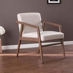 a chair sitting on top of a hard wood floor next to a potted plant