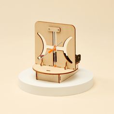 a clock made out of wood on top of a white stand