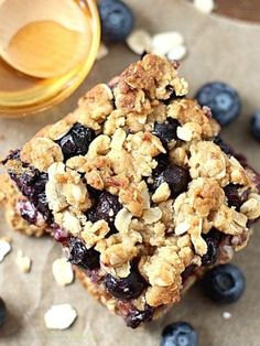 blueberry oatmeal breakfast bars on parchment paper next to a jar of honey