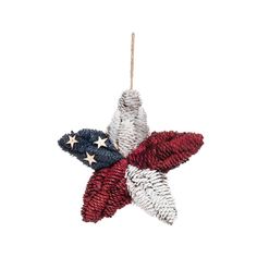 a red, white and blue star ornament hanging from a string on a white background