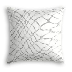 a white and grey pillow with an abstract design on the front, in shades of gray