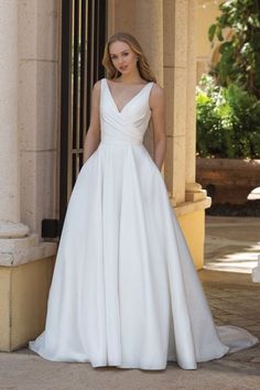 a woman in a white wedding dress standing outside