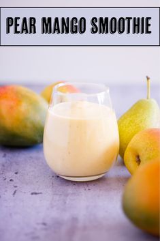 pear mango smoothie in a small glass next to fruit on a table with the words pear mango smoothie