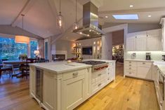 a large kitchen with white cabinets and an island in front of the stove top oven