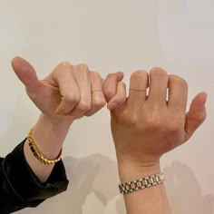 two people holding their hands up to each other with one hand on the other's wrist