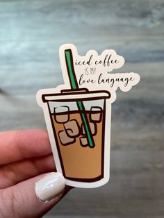 a hand holding up a sticker with a drink in the cup on it that says iced coffee is my love language