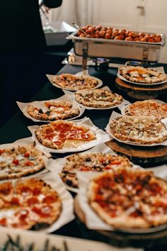 many different types of pizzas are on the table in front of other food items