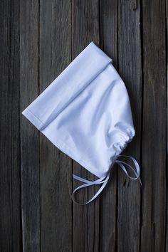 a white cloth bag tied to a wooden wall