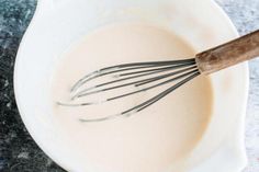 a whisk is in a bowl with milk