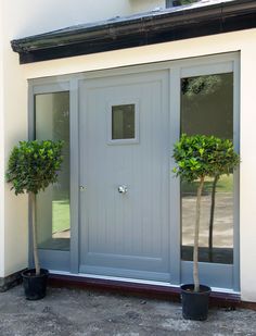 an advertisement for the external and external wooden doors, with two potted trees in front